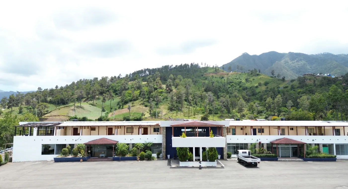 Fachada del Hotel Nueva Suiza con las montañas de Constanza detrás